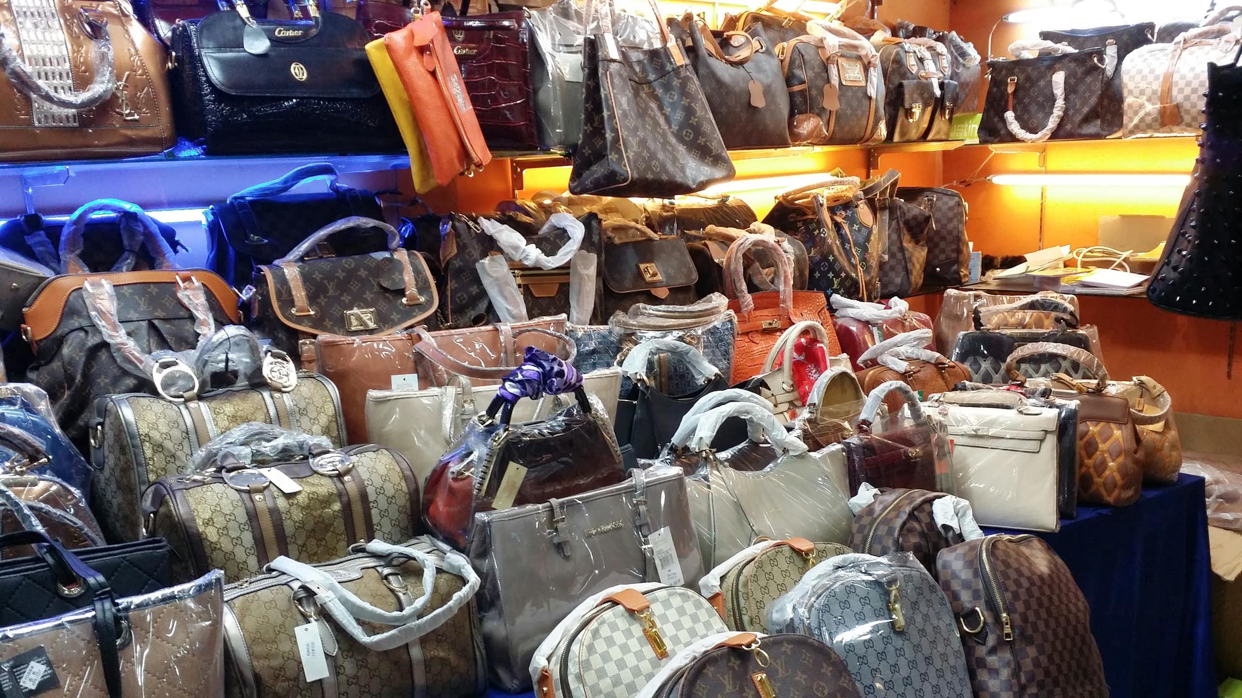 A display of counterfeit bags bearing the logos of the biggest names in luxury goods.