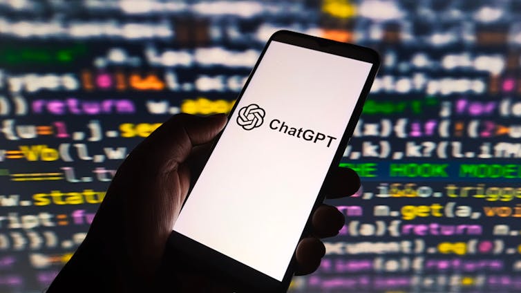 ChatGPT AI logo displayed on smartphone screen, with colorful computer code in background/