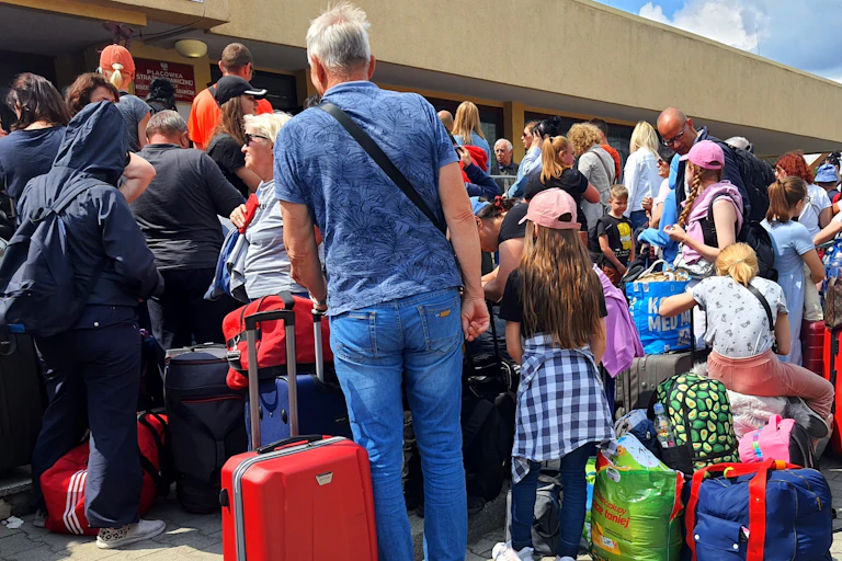 Personas se agolpan con su equipaje a la entrada de una estación