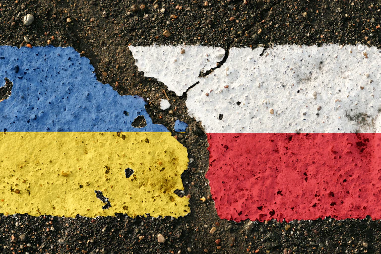 Banderas de Polonia y Ucrania desgarradas sobre un pavimento