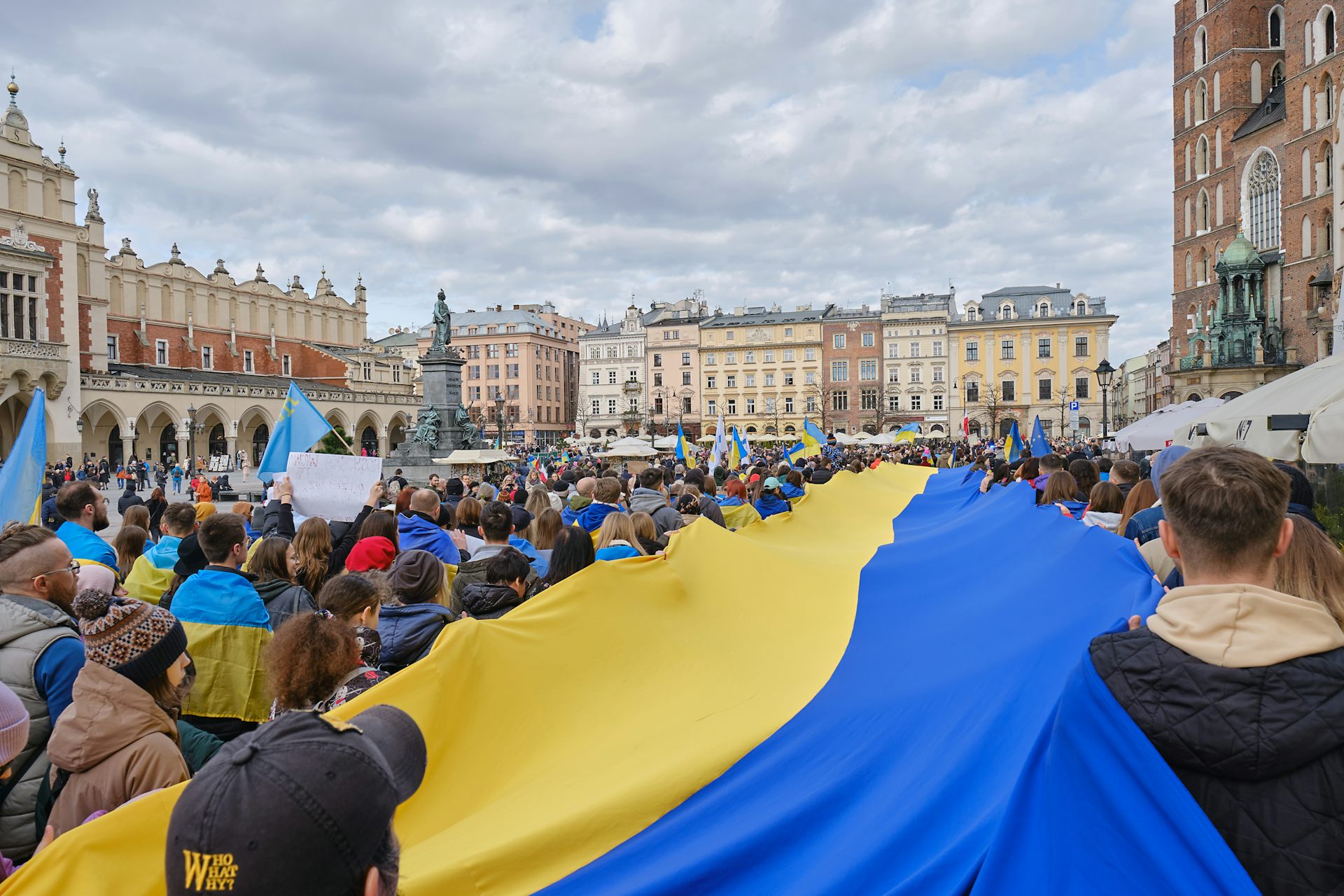 Varios manifestantes portan una bandera gigante de Ucrania