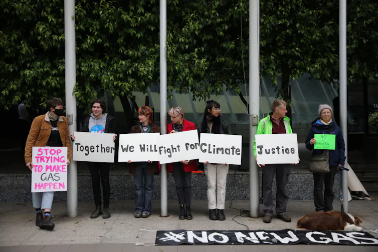 people in a line holding signs