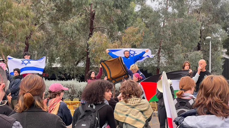 Protesters waving different Israeli and Palestinian flags.