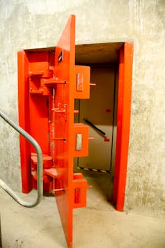 A red blast-proof metal door in a bunker.