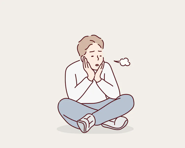 Man sitting on floor sighing