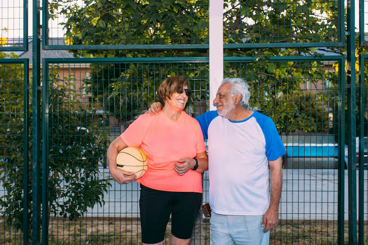 Un homme et une femme se tiennent côte à côte sur un terrain de basketball