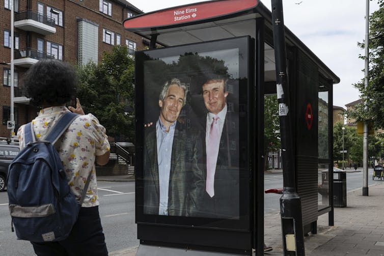 A bus stop in the U.K. featuring a photo of Donald Trump and Jeffrey Epstein standing together smiling. A bus stop in the U.K. featuring a photo of Donald Trump and Jeffrey Epstein standing together smiling.