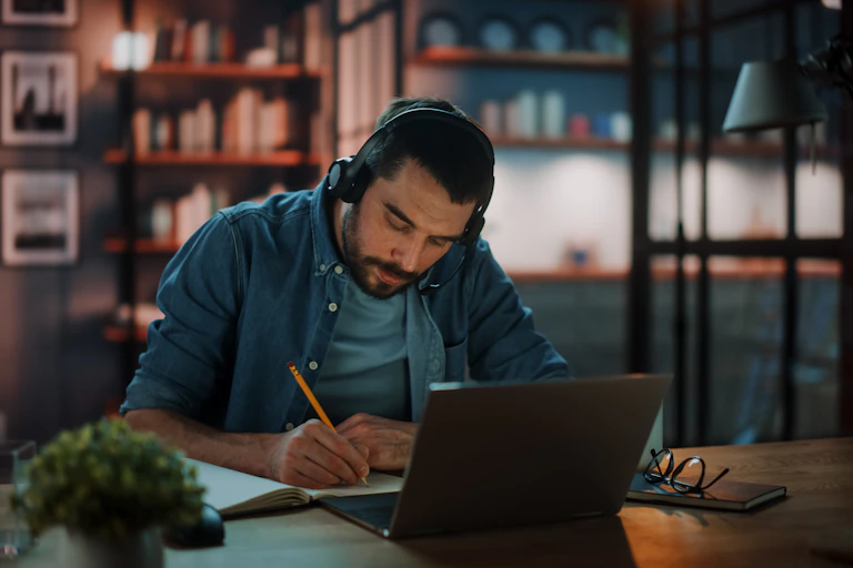man wearing headphones working from home with a laptop