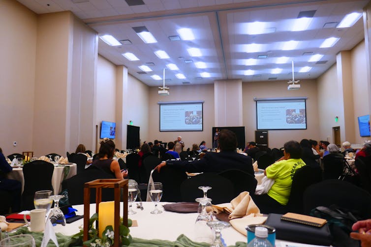 A group of people are assembled in a meeting room.
