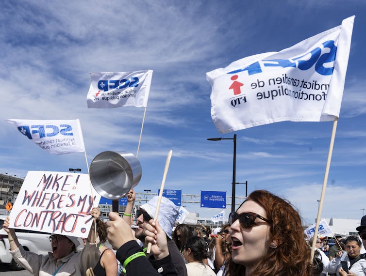Las personas dan banderas y los signos de protesta a favor de los asistentes de vuelo que requieren mejores condiciones de trabajo