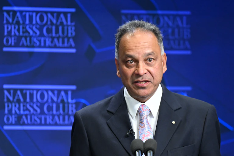 A man in a suit and tie, speaking to an audience at the National Press Club in Canberra.