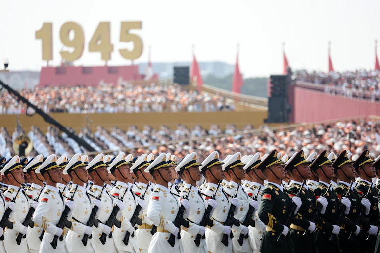 Chinese military parade in front of large sign saying 1945.