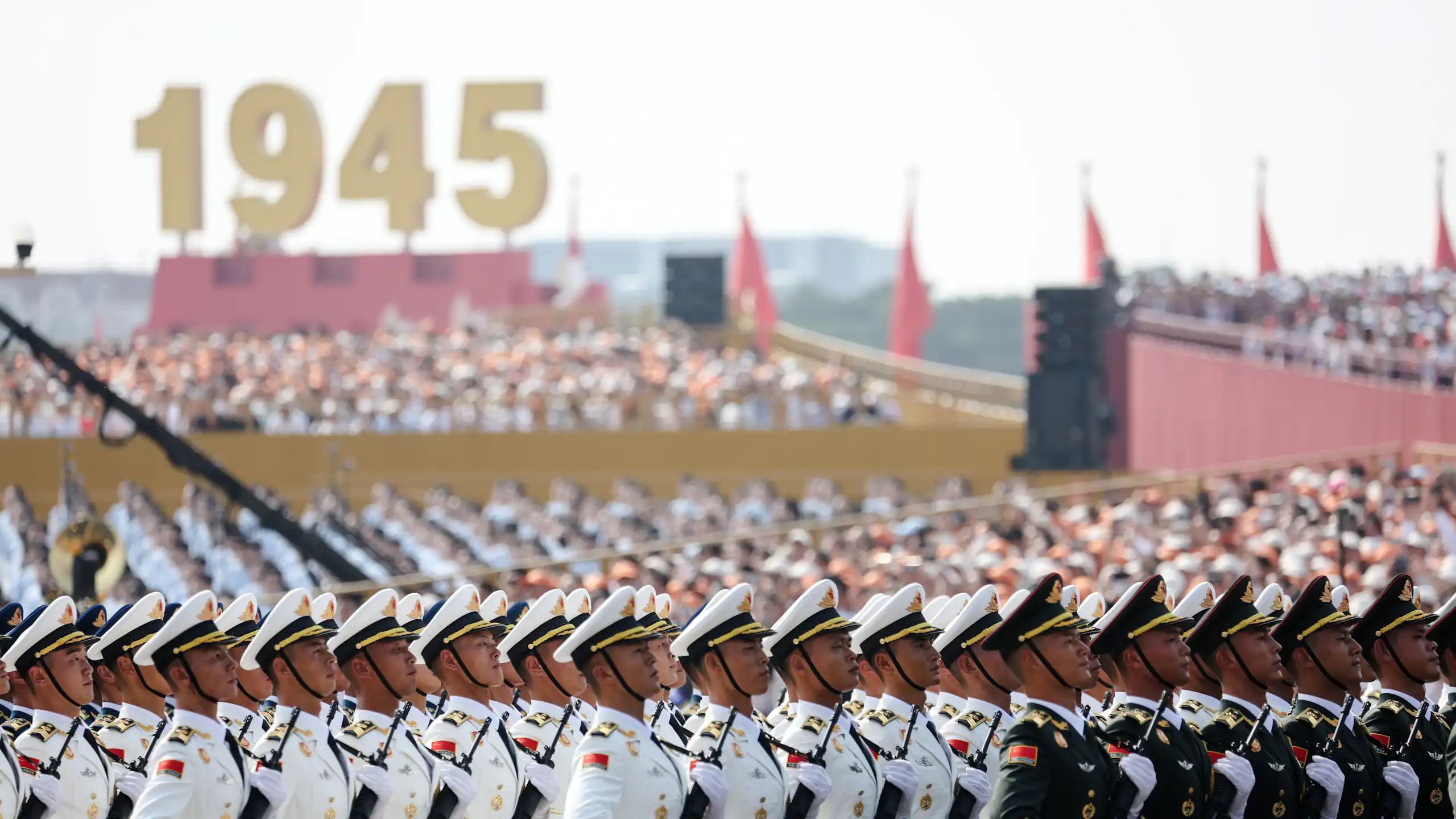 Chinese military parade in front of large sign saying 1945.