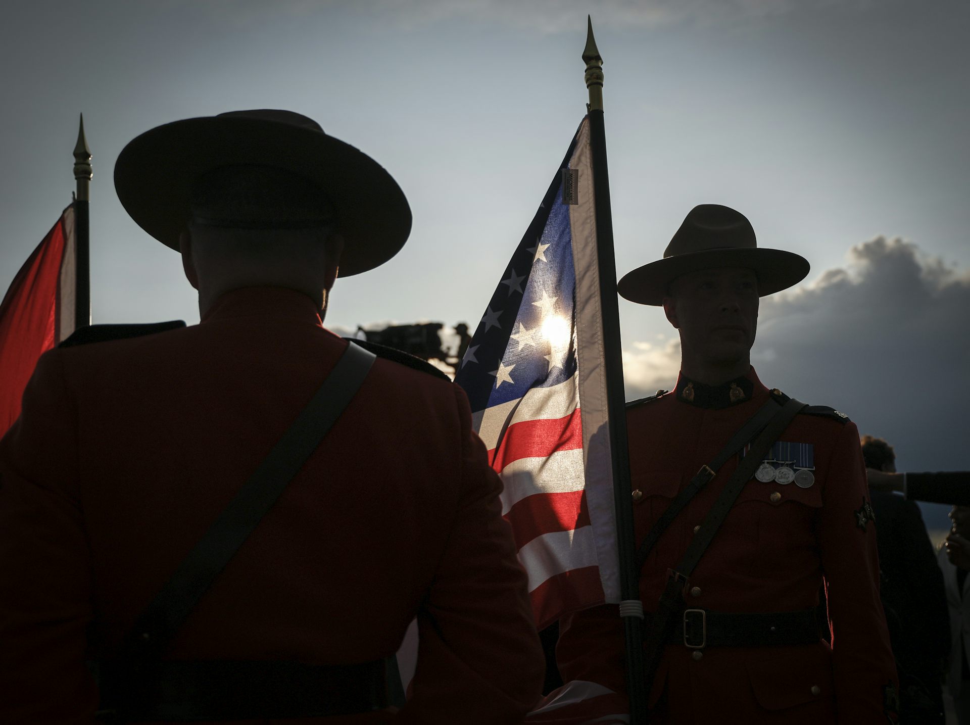 A patch of American flag between the silhouettes of Mounties wearing Stetsons.