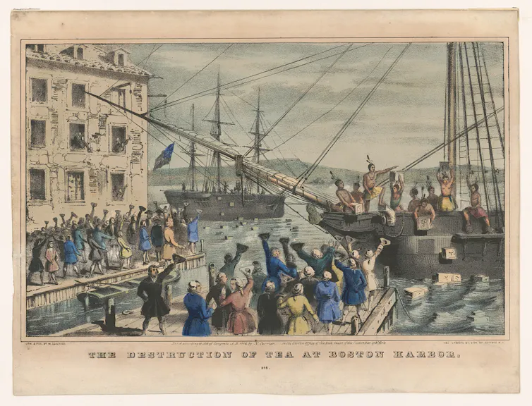 An illustration of colonists boarding ships in a harbour and dumping chests of tea into the water