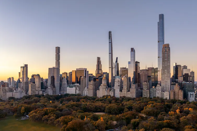 A view of part of the NYC skyline across Central Park, with several skinny towers sticking up on their own.