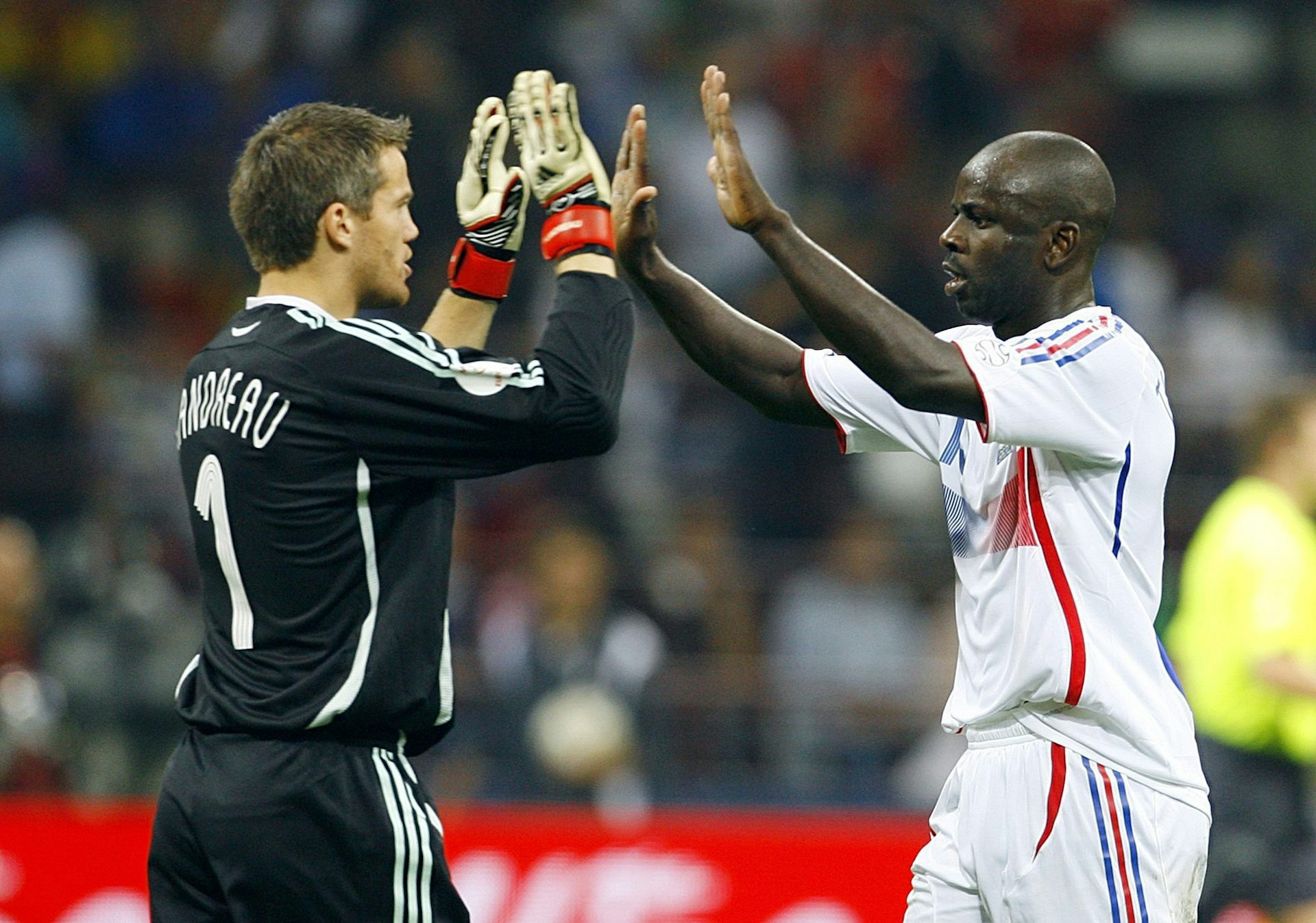 Deux joueurs de soccer se font des high five sur un terrain
