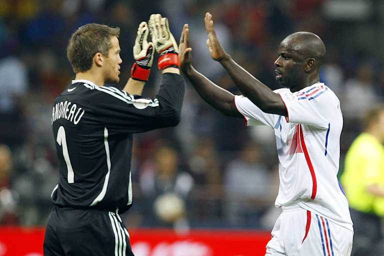Deux joueurs de soccer se font des high five sur un terrain