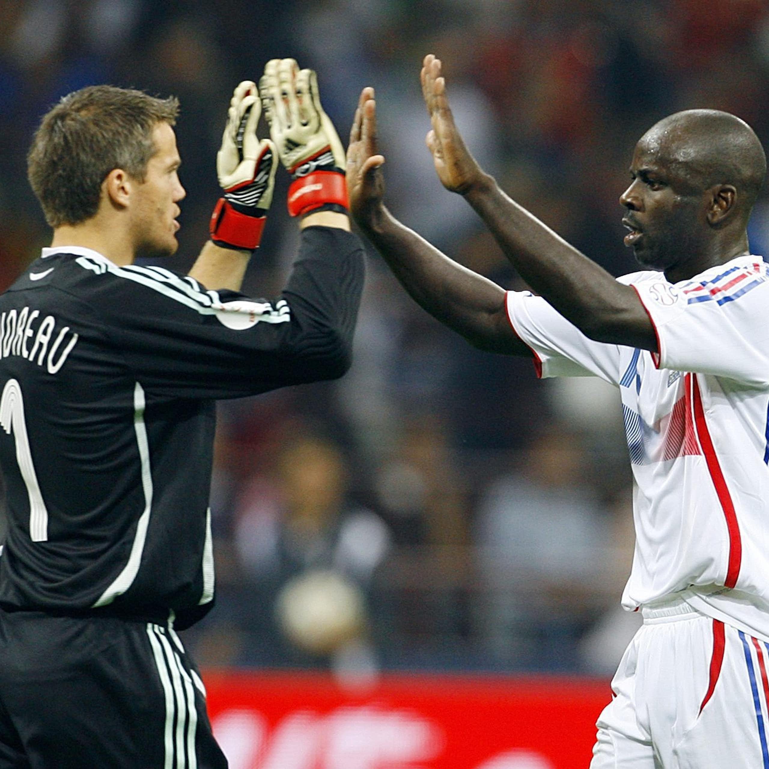 Deux joueurs de soccer se font des high five sur un terrain