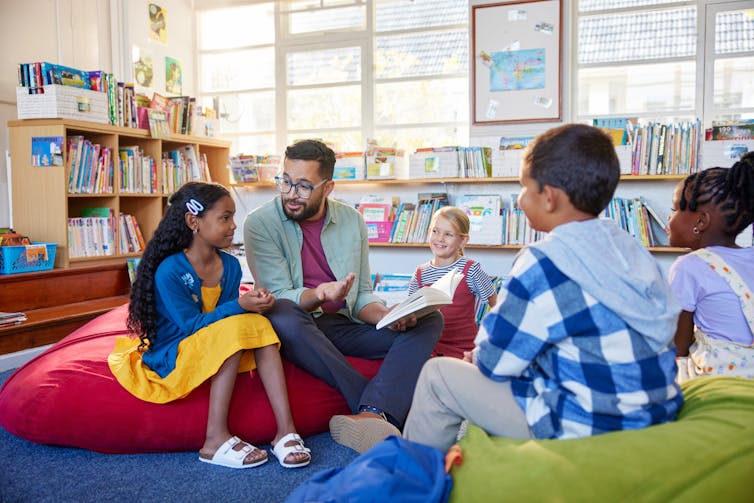 Teacher reading to children in school library