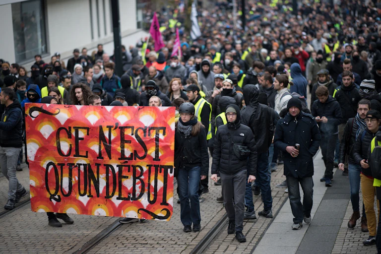 Des manifestants brandissant une banderole sur laquelle on peut lire « Ce n'est qu'un début »