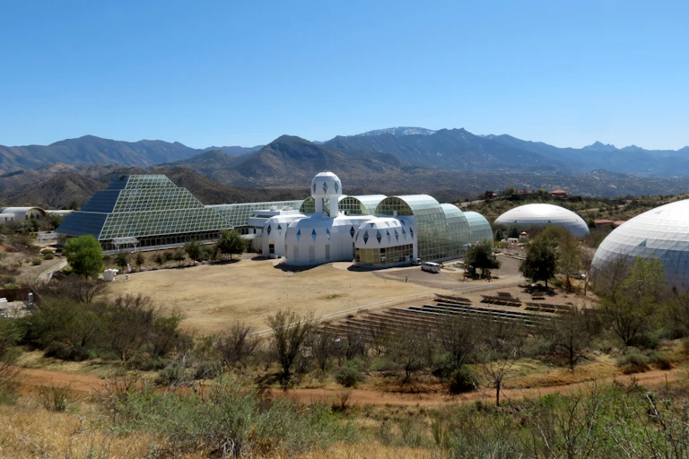 An eclectic set of partially domed and pyramidal buildings located in the desert.