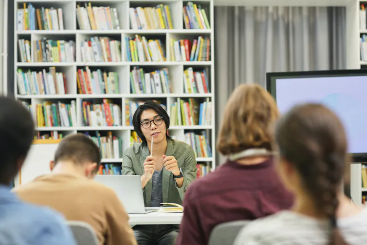 An instructor at the front of a classroom.