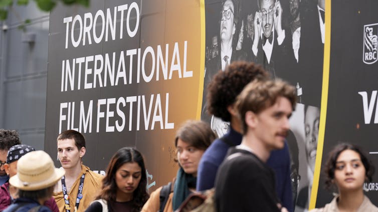 People stand in line outdoors.