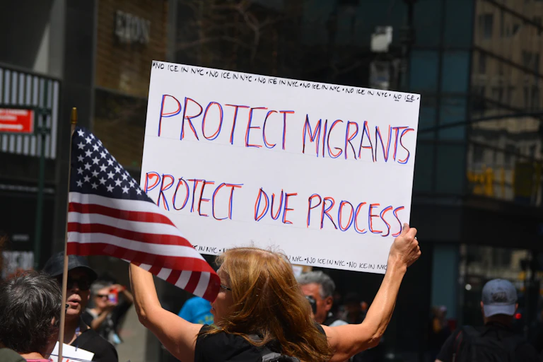 Una mujer enarbola una pancarta contra la política migratoria de la administración Trump