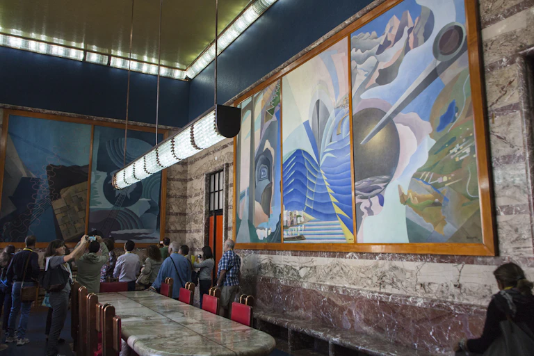 stylized murals in a marble-walled conference room with art deco light fixtures