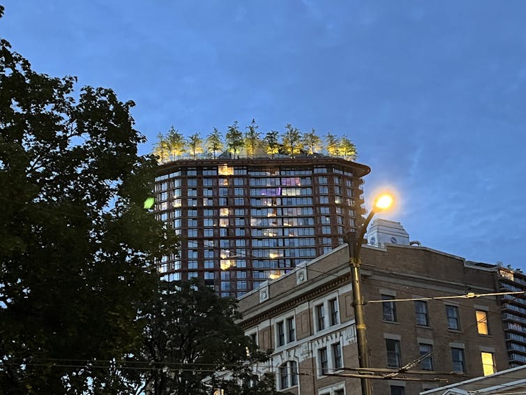 A high-rise building with trees on the roof