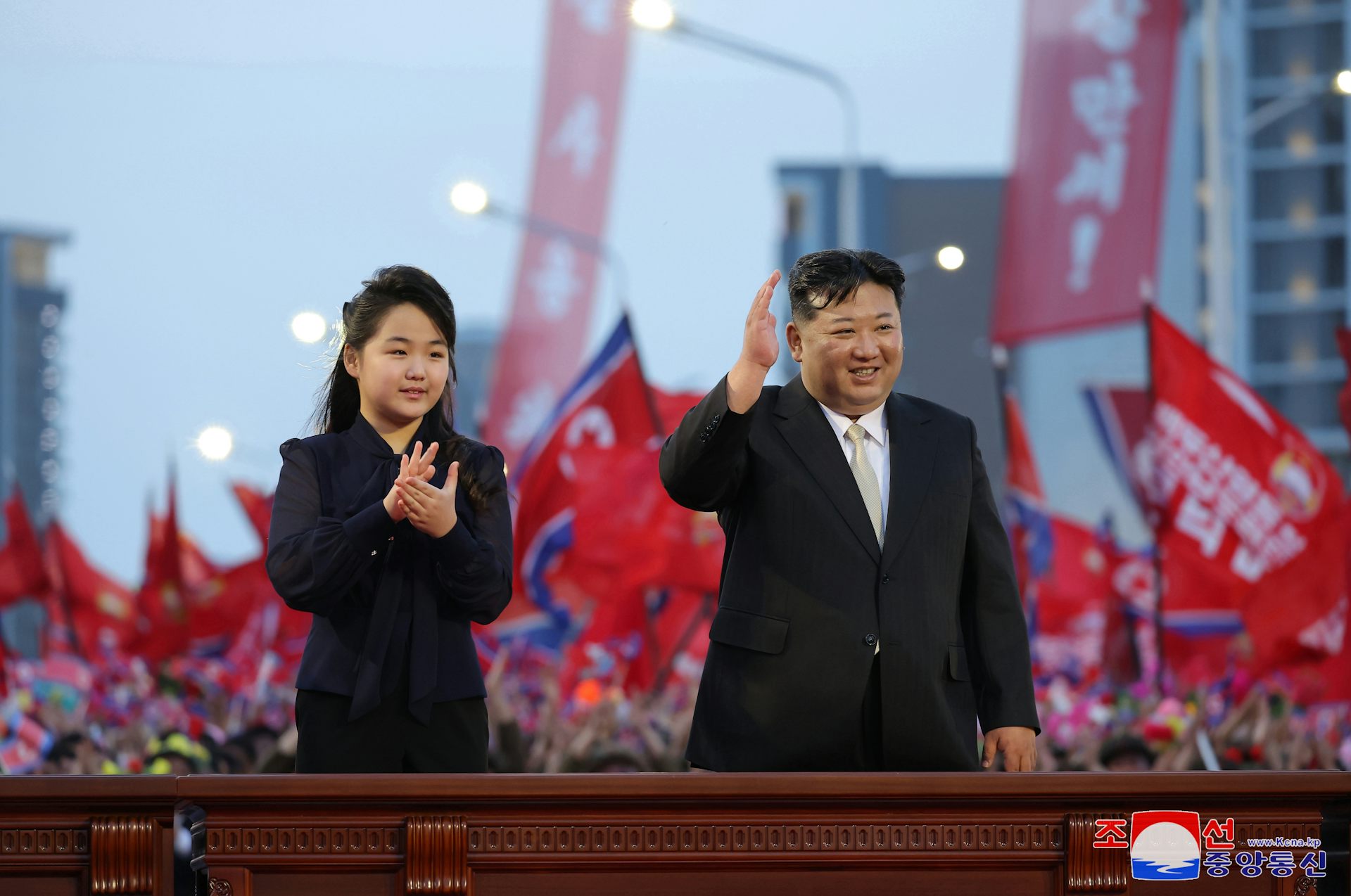 Kim Ju Ae and Kim Jong-un greet a crowd in North Korea.
