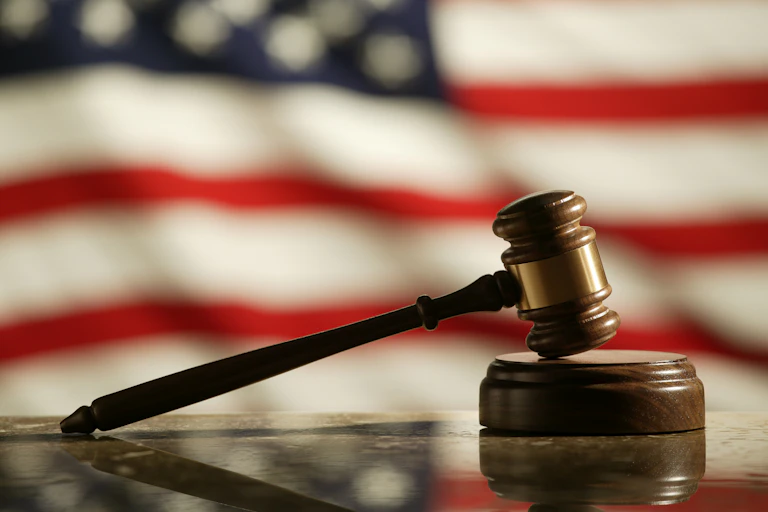 A US flag behind a judge's gavel.