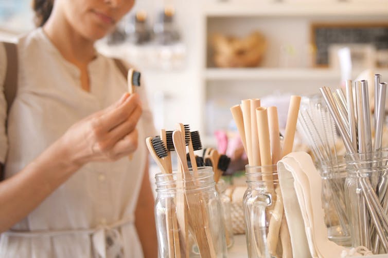 Woman Choosing Bamboo Eco Friendly Biodegradable Toothbrush in Zero Waste Shop