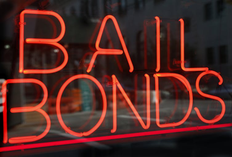 A fluorescent sign reads 'bail bonds.'