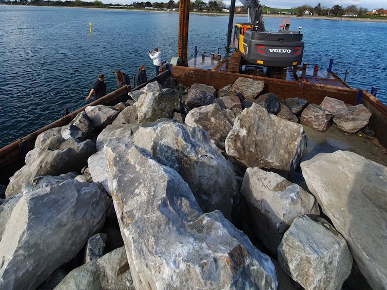 rocks by coast, with machinery