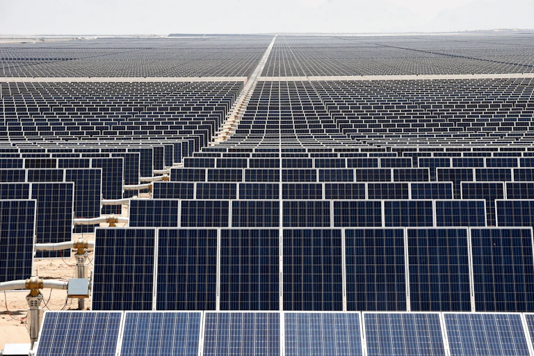 a very large solar farm, a view of solar panels in a desert stretching to the horizon