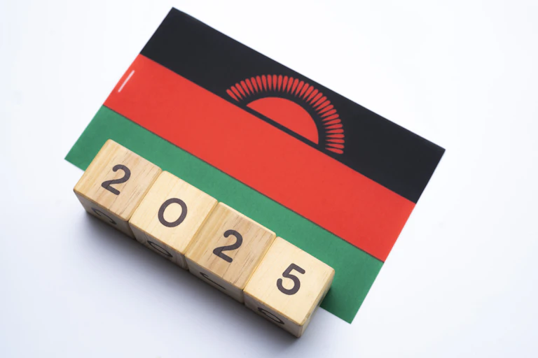 A graphic showing the flag of Malawi with four square wooden blocks underneath spelling out 2025