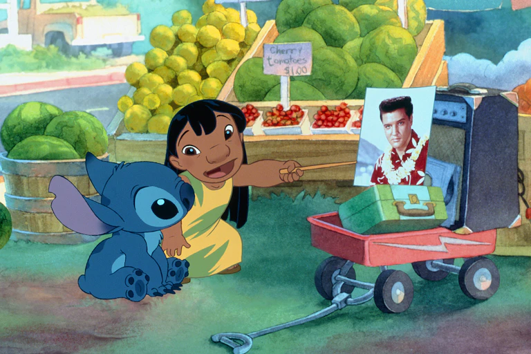 Una niña le explica a un monstruito quién es un señor en una foto con un collar hawaiano.