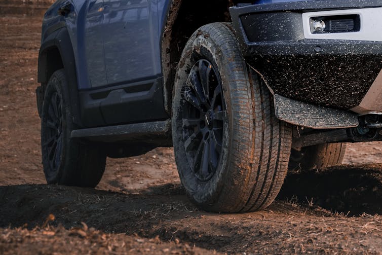 A closeup of an SUV tire on a dirt road.