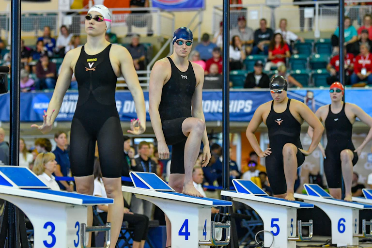 Four women prepare to swim in a race.