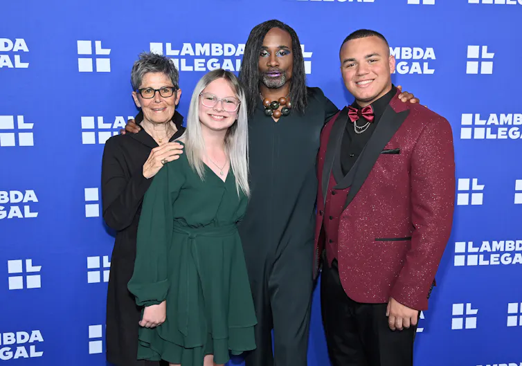 Four people stand together to be photographed.
