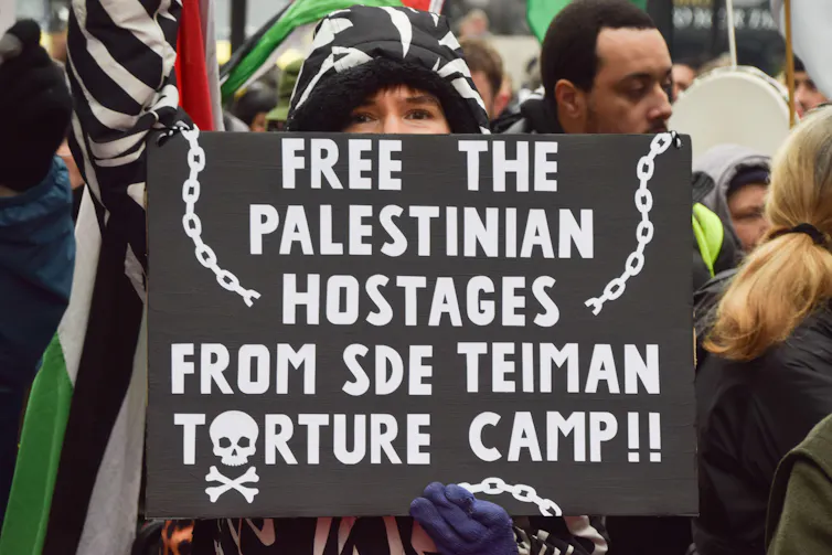 A UK protester with a sign calling for the release of Sde Teiman 'hostages'.