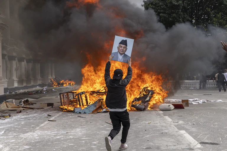 A protester prepares to burn a picture of resigned Prime Minister KP Sharma Oli during demonstrations in Kathmandu.