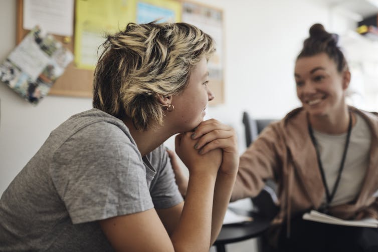 The side profile of a young person facing a smiling counsellor