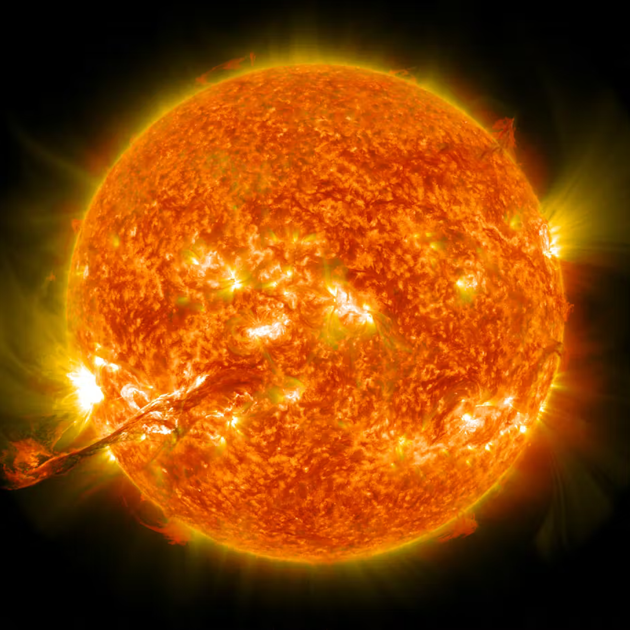A photo of the Sun with a massive finger of plasma extending from the bottom left into space.