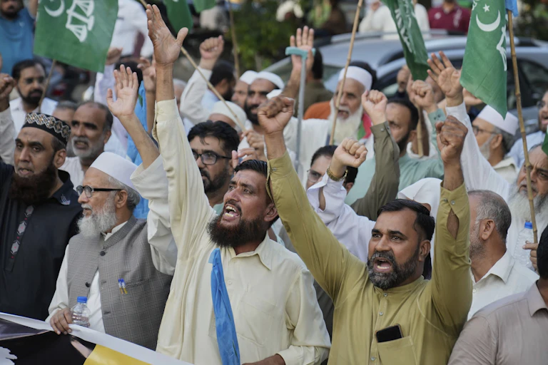 Bearded men with arms raised and chanting.