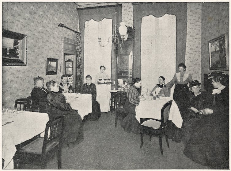 Women sit drinking tea in a room.
