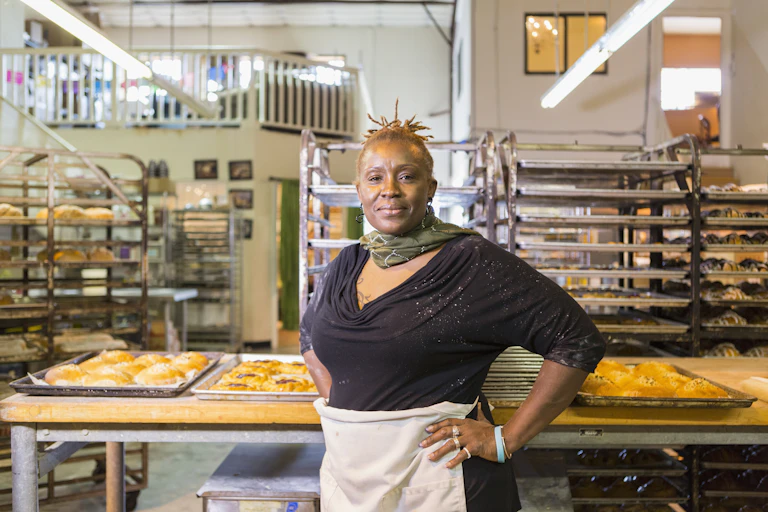 Woman stands in a bakery looking self-confident.