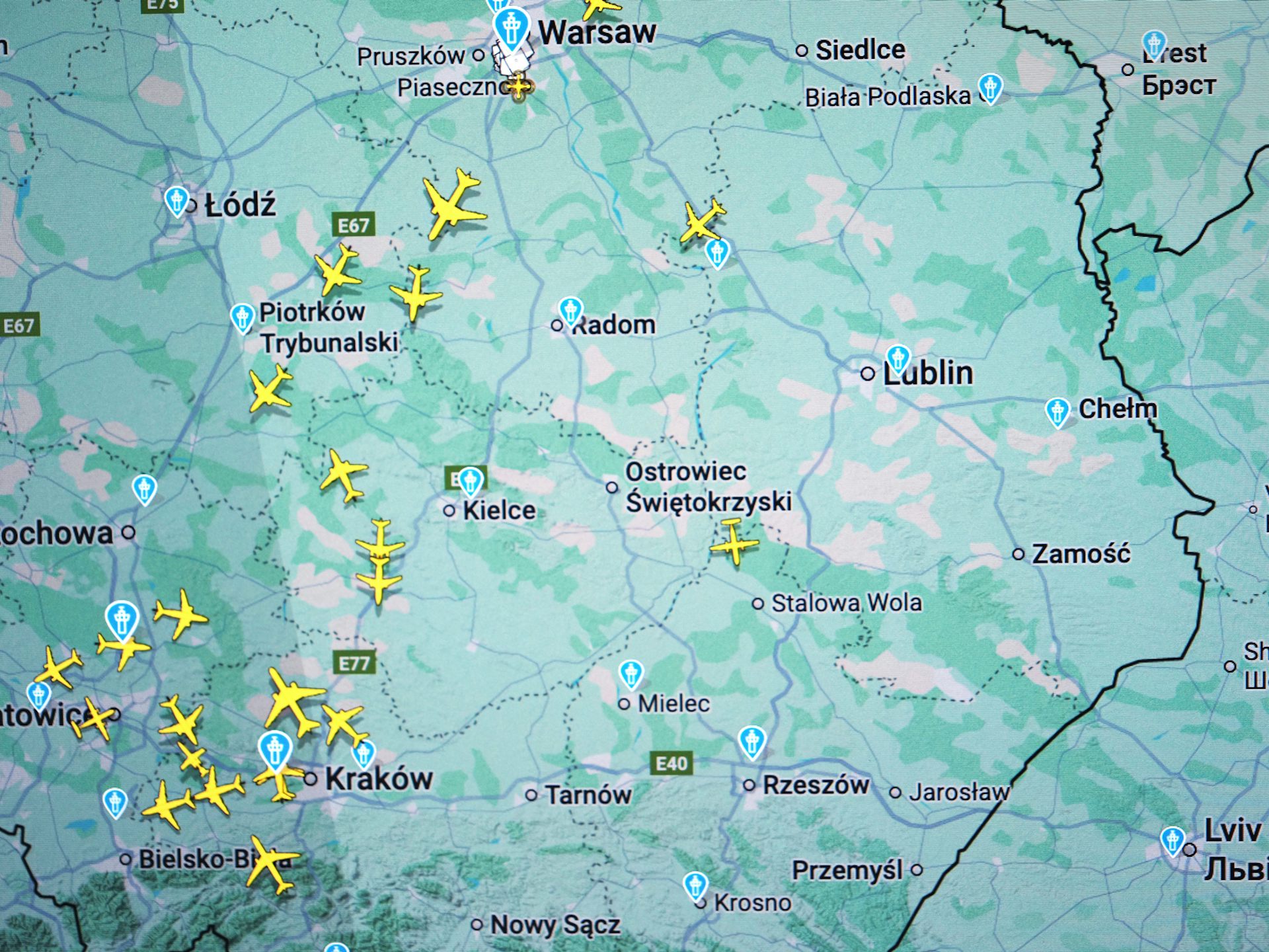 A screen shows small yellow airplanes over the west of a map.